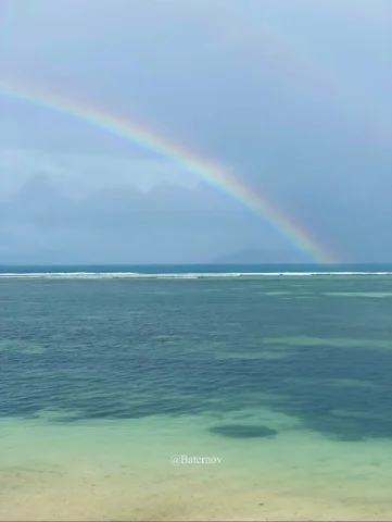 Rainbow above shallow turquoise water