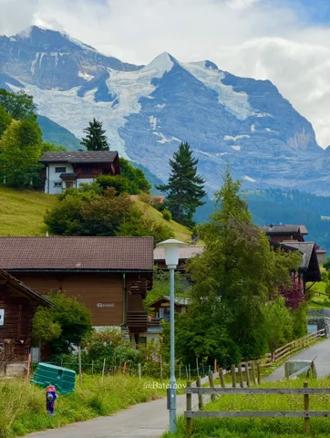 Village path and chalets beneath jagged mountain peaks