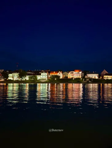 Illuminated waterfront reflected in dark water