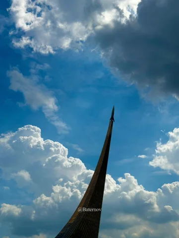 Slender monument rising into a cloud-filled sky