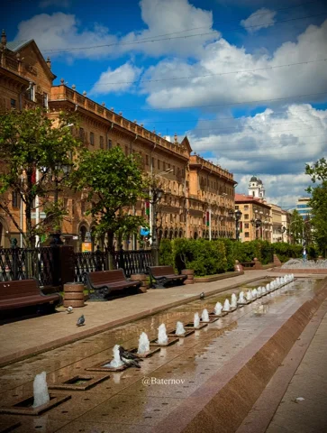 Long fountain beside warm-coloured urban facades