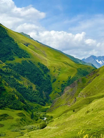 Green mountain slopes surrounding a narrow valley