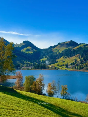 Blue lake between green hills and scattered houses
