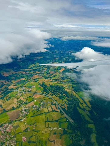 Aerial patchwork of fields beneath scattered clouds