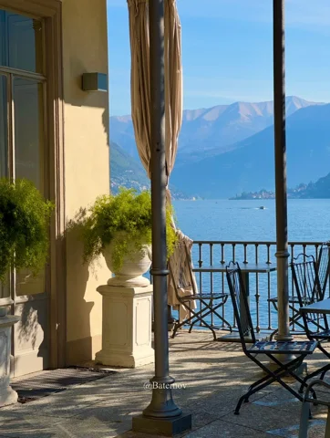 Terrace chairs overlooking a lake and distant mountains