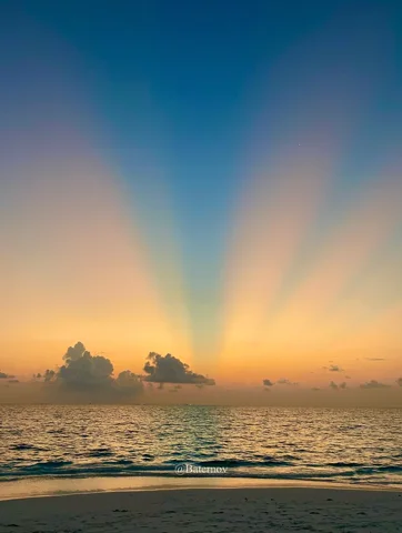 Rays of light spreading above the ocean horizon