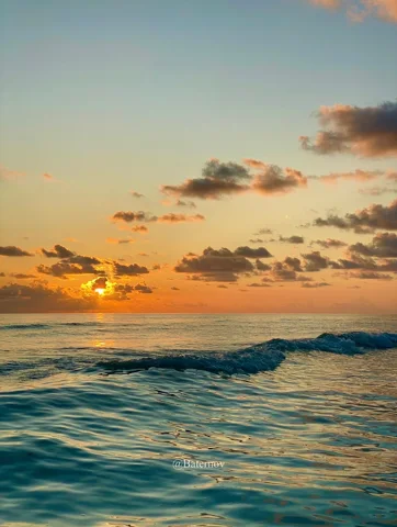 Ocean waves beneath an orange sunset