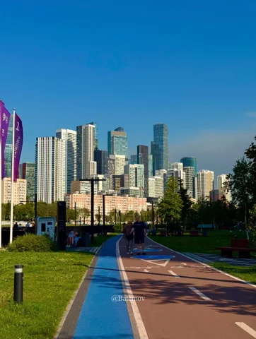 Coloured walking and cycling paths leading toward skyscrapers
