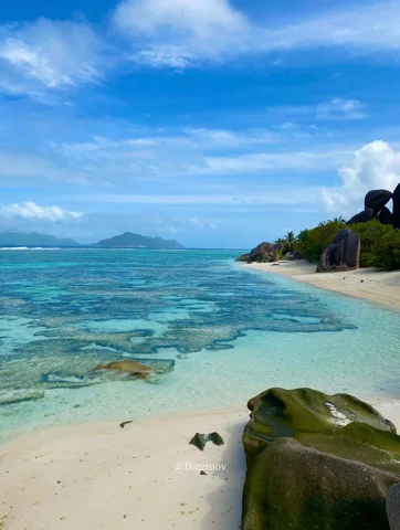 Rocky shoreline beside a bright tropical beach