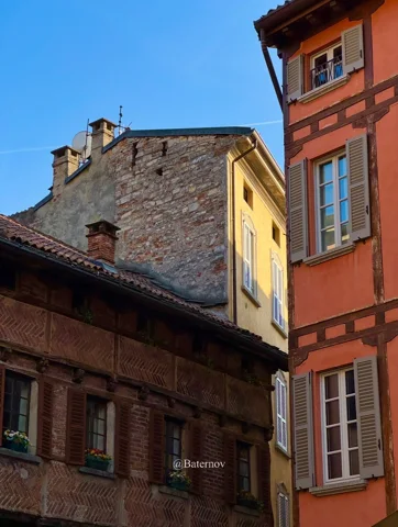 Tall pastel facades around a narrow village street