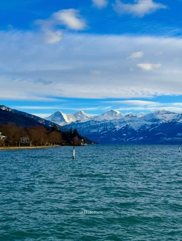 Rippling lake beneath snowy peaks and blue sky