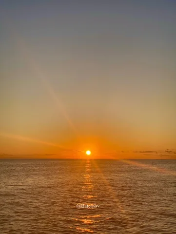 Orange sun above a calm sea