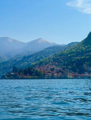 Lakeside settlement beneath wooded mountain slopes