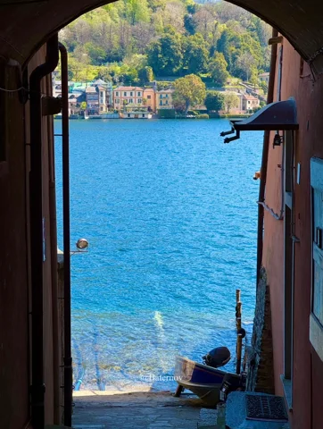 Blue lake seen through a narrow passage between buildings
