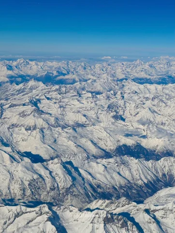 Aerial view of a vast snow-covered mountain range