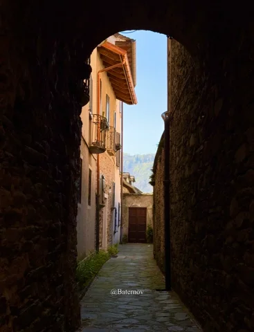 Stone archway opening onto a sunlit alley