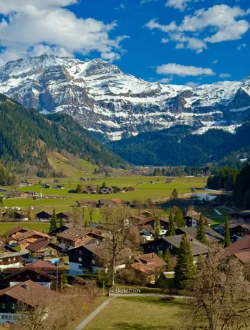 Mountain village below a broad snow-covered massif