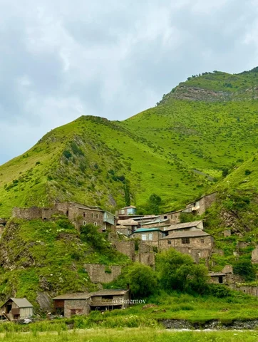 Stone houses on a steep grassy slope