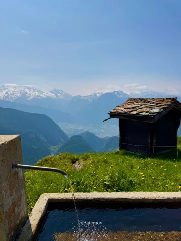 Wooden hut and water trough overlooking distant mountains