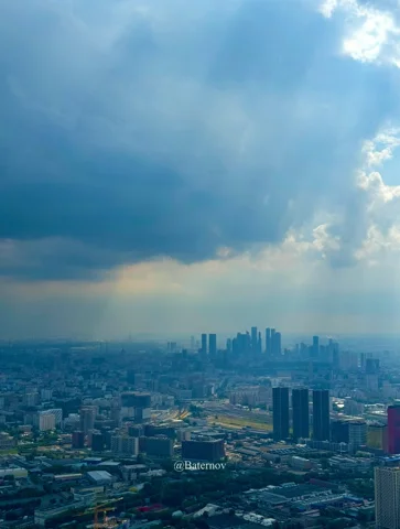 Distant skyline beneath sunlight breaking through storm clouds