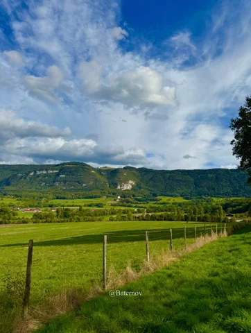 Fence beside fields and a rocky ridge