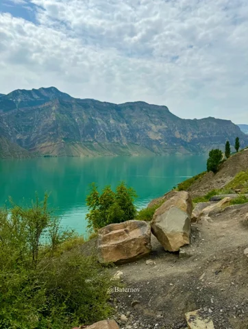 Rocky path beside a turquoise mountain lake