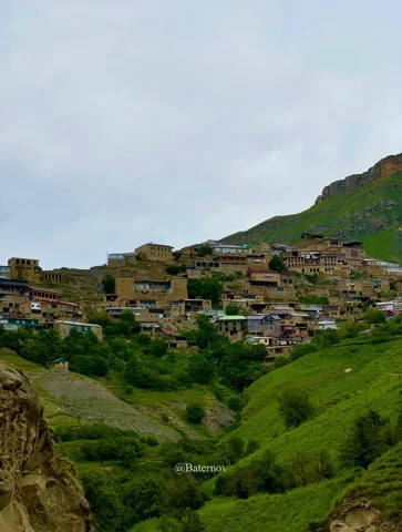 Terraced village houses across a green hillside