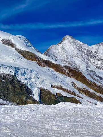 Snow-covered mountain slope beneath a blue sky